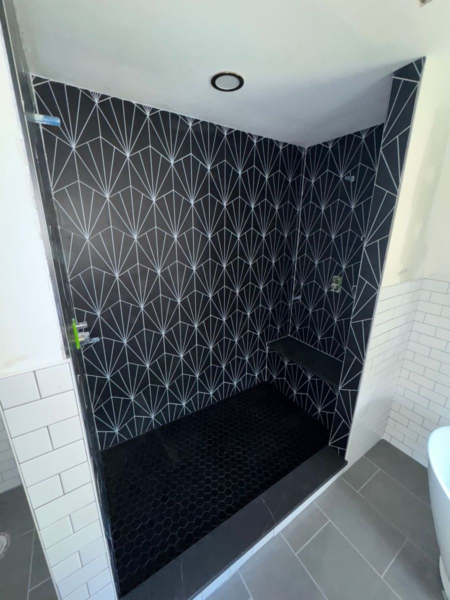 Floor-to-ceiling shower in black fan-pattern tile with hexagon floor, built by PRZ in Concord
