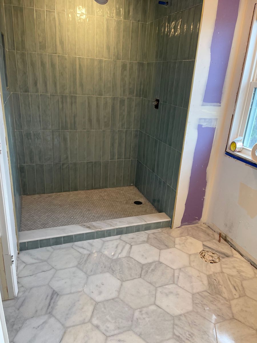 Sage-green vertical tile shower with marble hexagon floor, built by PRZ in Surf City